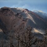 a view of the top of a mountain with clouds in the sky